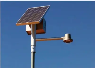 Fotografía de un luminaria de alumbrado público alimentada por un panel solar instalado sobre un poste.