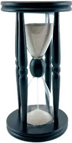Reloj de arena de madera oscura con la arena cayendo del recipiente superior al inferior, un instrumento antiguo para medir el tiempo.