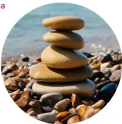 Piedras apiladas sobre arena y agua, ejemplo de materia inerte o abiótica.