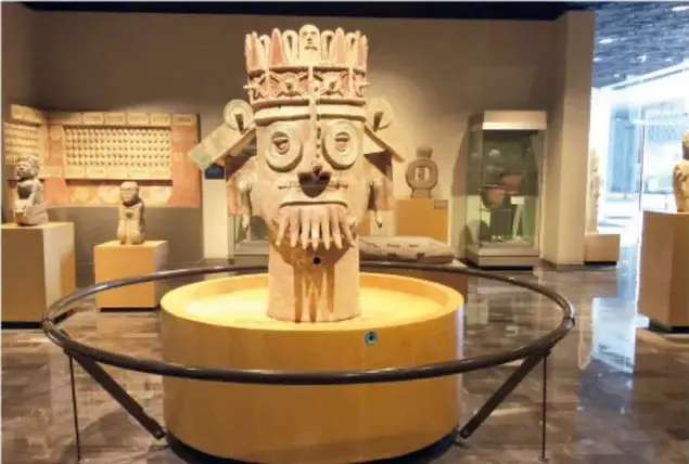 Vasija o escultura ceremonial con rostro tallado, exhibida en una sala del museo.