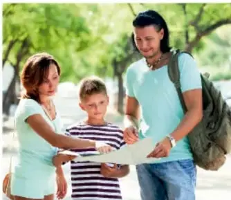 Fotografía de una familia (madre, padre e hijo) al aire libre; el padre sostiene un mapa y los tres observan y conversan, representando la colaboración familiar.