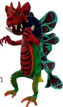 Fotografía de un alebrije de papel maché: criatura imaginaria con cuerpo rojo y verde, fauces abiertas con dientes, alas y cola decoradas con motivos florales.