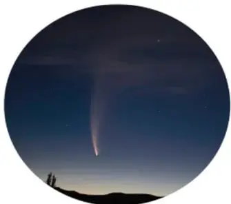 Fotografía circular nocturna de un cometa con cola visible sobre el horizonte.