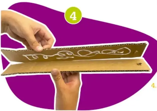 Manos uniendo dos tiras de cartón con dobleces en forma de pestañas, paso 4.
