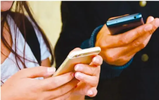 Fotografía de dos personas jóvenes sosteniendo y utilizando teléfonos inteligentes con pantalla táctil.