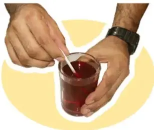 Manos insertando popotes en el globo que tapa el frasco.