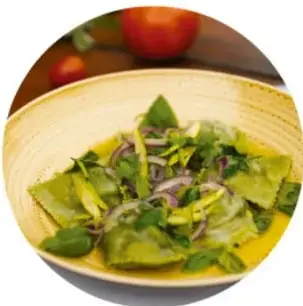 Tazón con pozole blanco, rábanos, lechuga y limón.