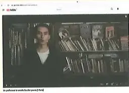 Miniatura de video en el panel Competencia digital: imagen de una persona frente a estantes de libros (aspecto de librería o biblioteca), posiblemente un escritor o profesor que enseña a escribir poesía. Se usa como thumbnail del enlace lynk.ec/8y33.