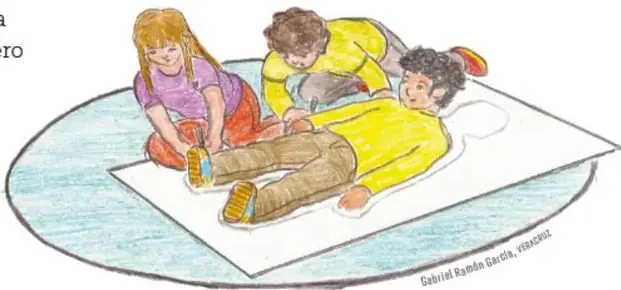 Tres estudiantes trazan la silueta de un compañero acostado sobre un cartón grande en el piso.