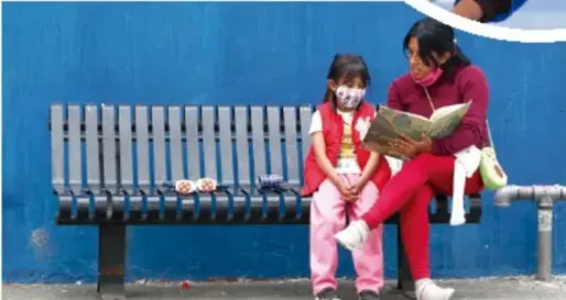 Fotografía circular de dos niñas en manta escolar cooperando en una actividad juntas.