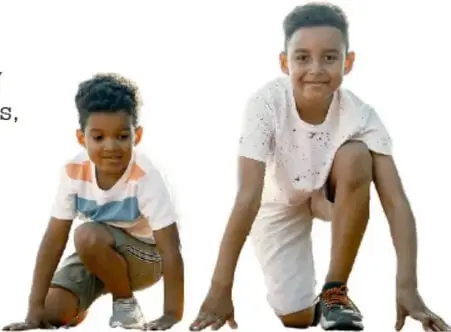 Dos niños en cuclillas en posición de salida, listos para hacer ejercicio.