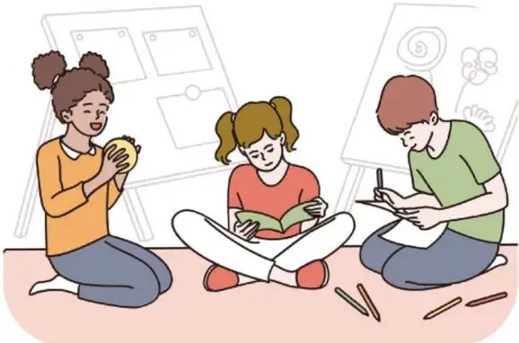 Ilustración de tres estudiantes sentados en el suelo trabajando en equipo: una niña sostiene un croquis, otra lee un libro y un niño escribe. Detrás hay pizarrones con dibujos y lápices de colores en el piso.