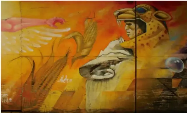 Mural o pintura de colores cálidos (naranjas, amarillos) que muestra un rostro humano entre elementos naturales como maíz, aves y formas abstractas, representando la identidad y creación artística mexicana.