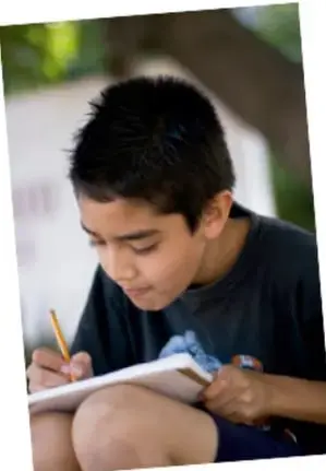 Niño escribiendo en un cuaderno.