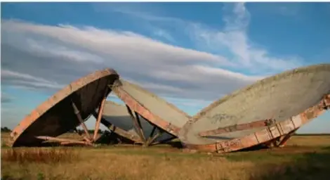 Fotografía de antenas parabólicas en un paisaje abierto.