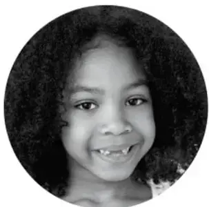 Fotografía en blanco y negro, en óvalo, de una niña sonriendo.